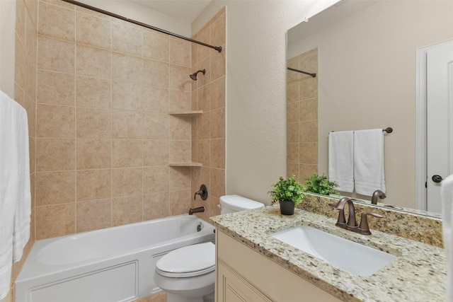 full bathroom featuring toilet, vanity, and tiled shower / bath