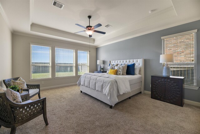 carpeted bedroom featuring ceiling fan, crown molding, and a raised ceiling