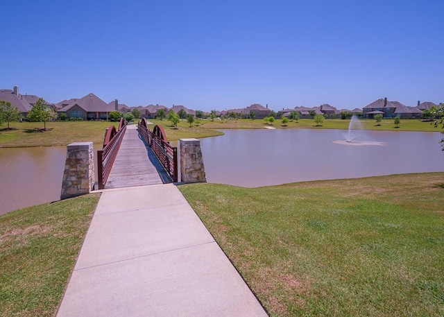 dock area featuring a lawn and a water view