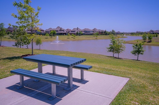 view of community with a yard and a water view