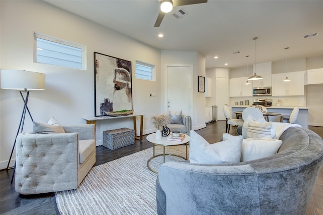 living room featuring a wealth of natural light, ceiling fan, and dark hardwood / wood-style flooring