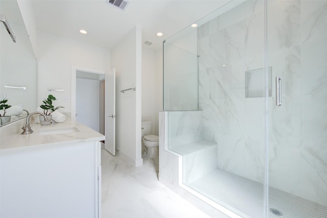 bathroom with toilet, vanity, and a shower with shower door