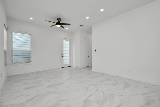 spare room with ceiling fan and a wealth of natural light