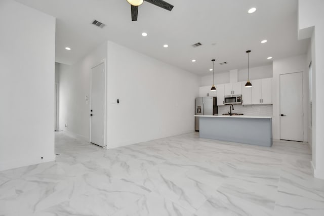 unfurnished living room with ceiling fan and sink