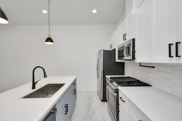 kitchen featuring appliances with stainless steel finishes, sink, white cabinetry, decorative light fixtures, and tasteful backsplash