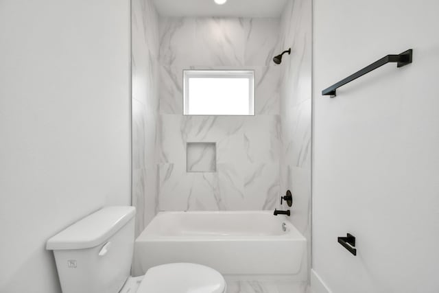 bathroom featuring toilet and tiled shower / bath combo