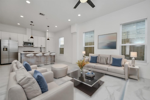 living room featuring sink and ceiling fan