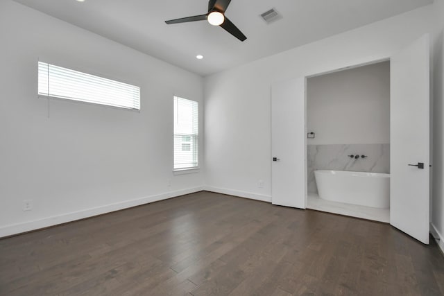 unfurnished bedroom featuring ceiling fan, dark wood-type flooring, and ensuite bath