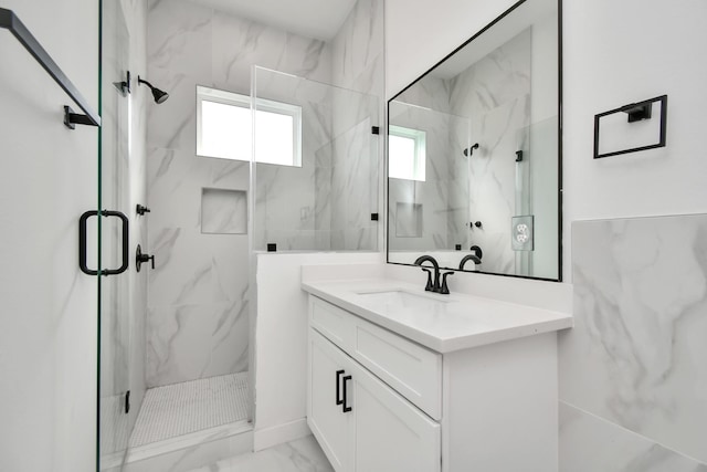 bathroom with a shower with door and vanity