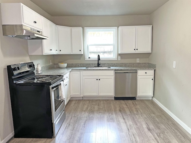 kitchen with sink, white cabinets, light wood-type flooring, light stone countertops, and appliances with stainless steel finishes