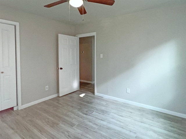 unfurnished bedroom with ceiling fan, light hardwood / wood-style flooring, and a closet