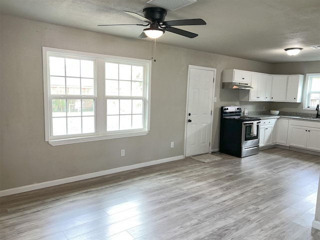 kitchen featuring sink, stainless steel electric range, a wealth of natural light, and white cabinetry