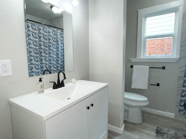 bathroom with toilet, vanity, and hardwood / wood-style flooring