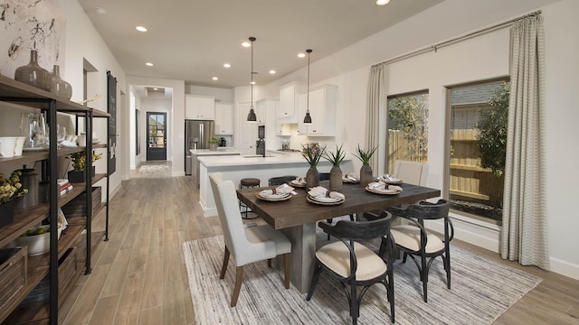 dining area with sink and light wood-type flooring