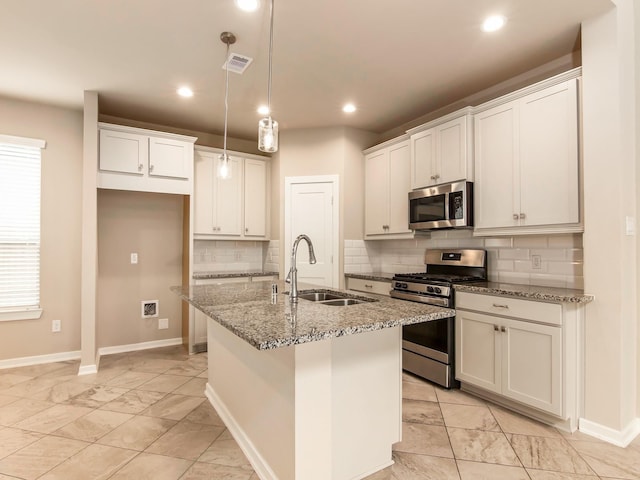 kitchen with sink, pendant lighting, an island with sink, and appliances with stainless steel finishes