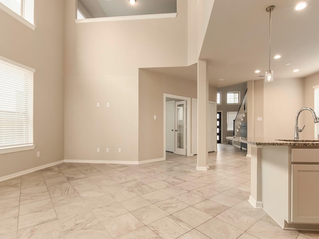 interior space featuring sink, a healthy amount of sunlight, and a towering ceiling