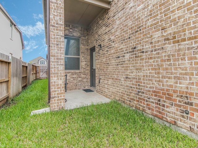 entrance to property with a yard and a patio area