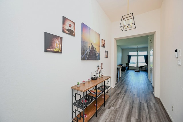 hall with a notable chandelier and hardwood / wood-style flooring