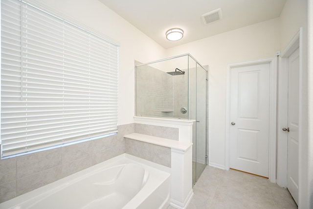 bathroom with tile patterned flooring and separate shower and tub