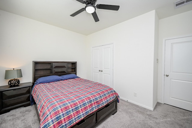 bedroom with ceiling fan, light colored carpet, and a closet