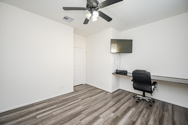 office space with built in desk, ceiling fan, and light hardwood / wood-style floors