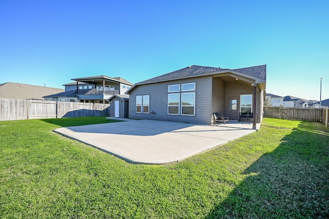 back of house with a yard and a patio