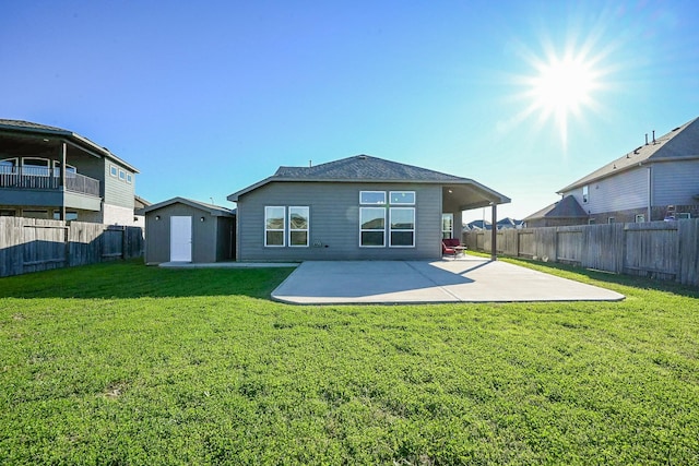 rear view of house with a yard, a patio area, and a shed