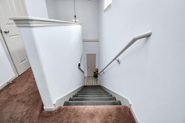 staircase with a towering ceiling and carpet