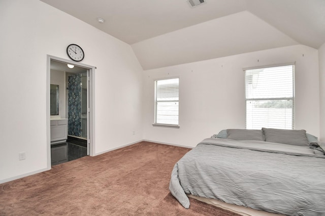 bedroom featuring lofted ceiling, ensuite bath, and carpet