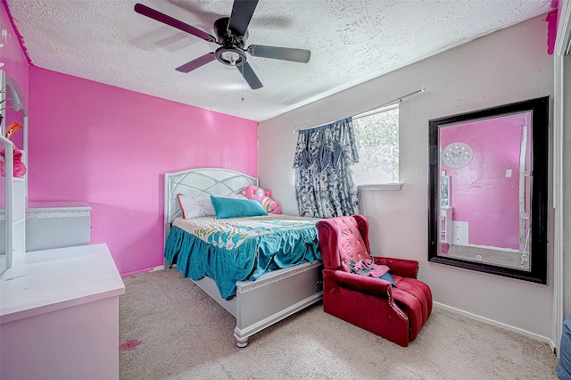 bedroom with ceiling fan, light carpet, and a textured ceiling