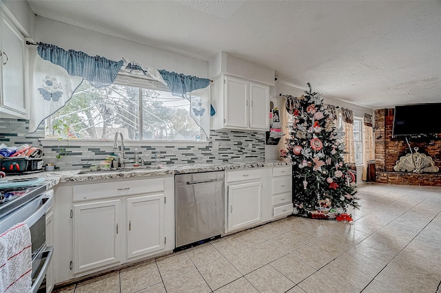 kitchen featuring backsplash, white cabinetry, a textured ceiling, and appliances with stainless steel finishes