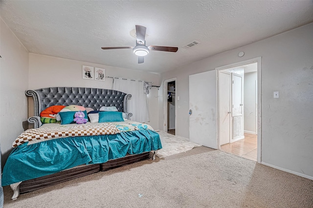 carpeted bedroom featuring a textured ceiling and ceiling fan