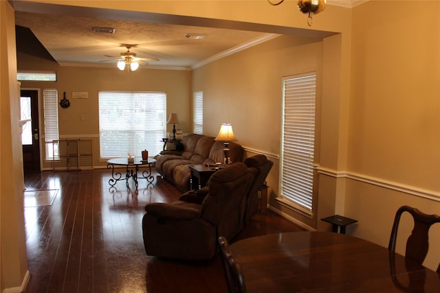 living room with dark hardwood / wood-style flooring, ornamental molding, and ceiling fan