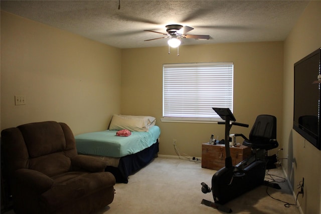 bedroom with ceiling fan, light colored carpet, and a textured ceiling