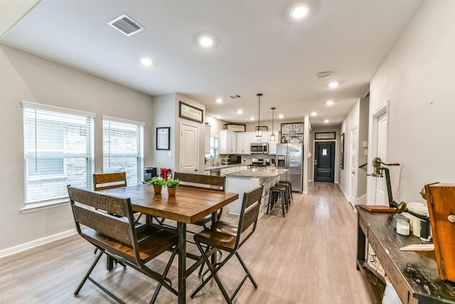 dining room featuring a wealth of natural light, light hardwood / wood-style floors, and sink