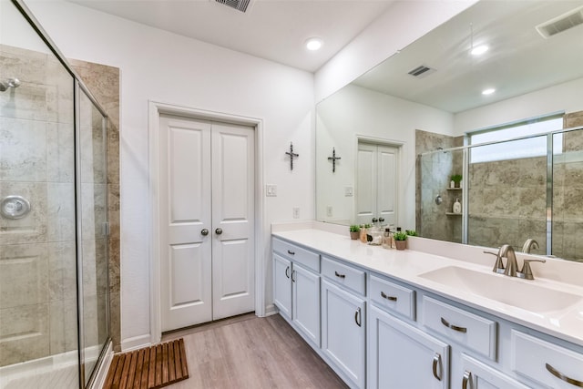 bathroom featuring a shower with shower door, wood-type flooring, and vanity