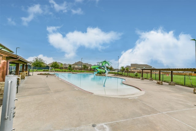 view of swimming pool featuring a water slide and a patio