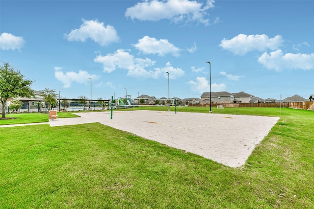 view of community with a lawn and volleyball court