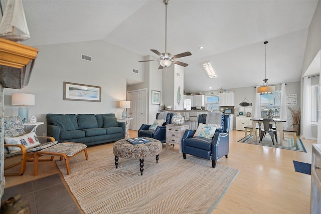 living room with high vaulted ceiling, ceiling fan, and light hardwood / wood-style floors