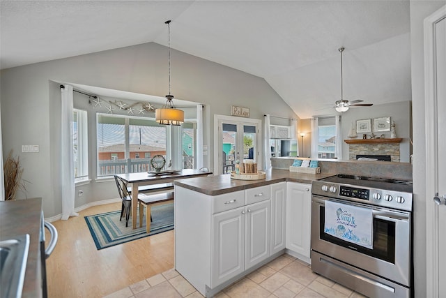 kitchen featuring stainless steel range with electric cooktop, french doors, white cabinets, and lofted ceiling