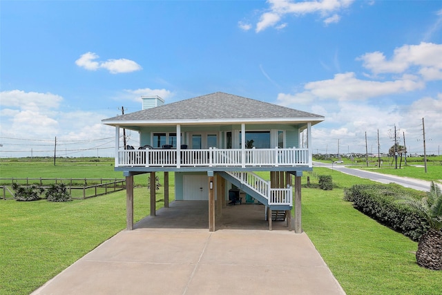 raised beach house with a porch, a garage, and a front yard