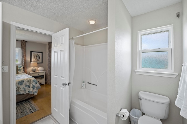 bathroom with a textured ceiling, wood-type flooring, shower / tub combo with curtain, and toilet