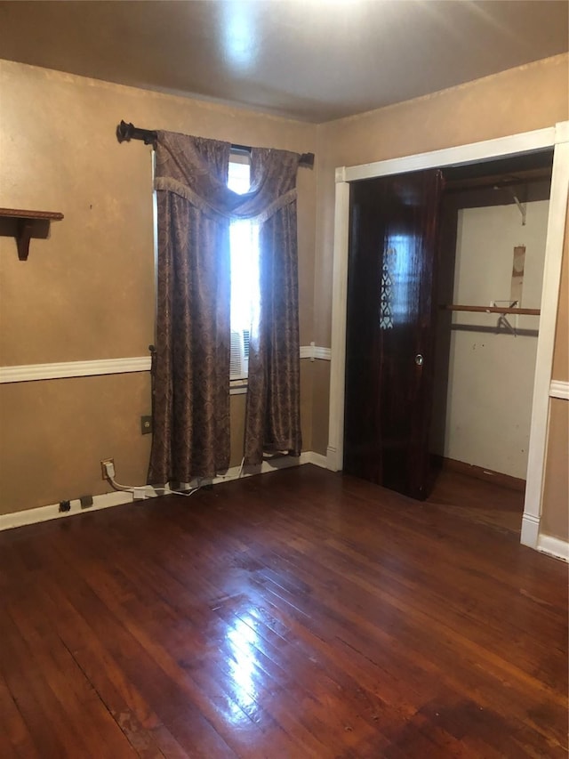 unfurnished bedroom featuring a closet and hardwood / wood-style flooring