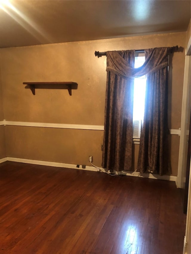 unfurnished room with dark hardwood / wood-style flooring