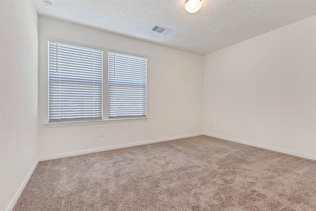 empty room featuring a textured ceiling and carpet flooring