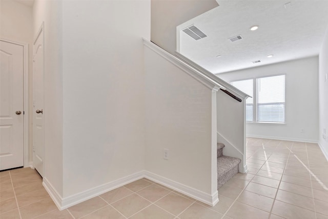 stairs featuring tile patterned flooring