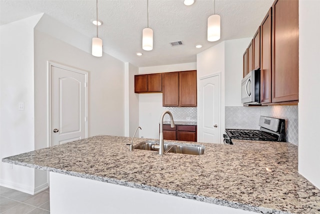 kitchen with sink, pendant lighting, kitchen peninsula, and appliances with stainless steel finishes