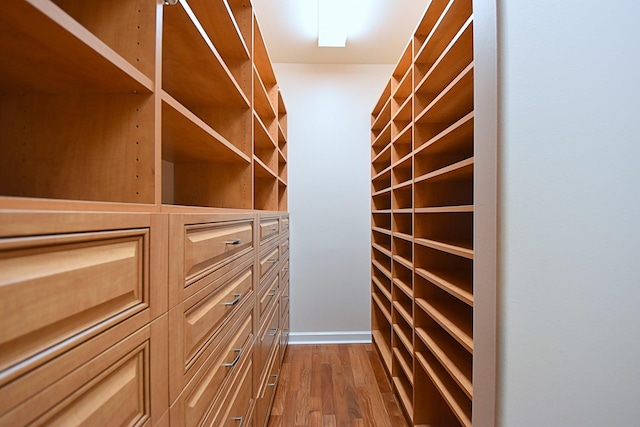 walk in closet with hardwood / wood-style flooring