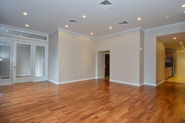 spare room featuring light hardwood / wood-style floors and crown molding