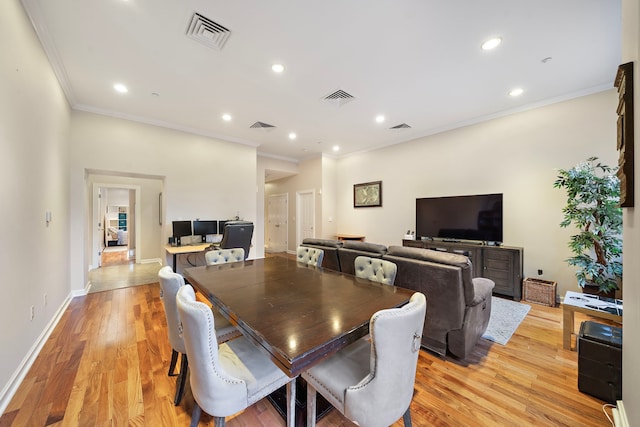 dining space with crown molding and light wood-type flooring